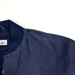 a navy vintage lacoste bomber jacket with embroidered green crocodile logo