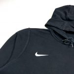 embroidered swoosh logo on the right hand side of black nike hoodie