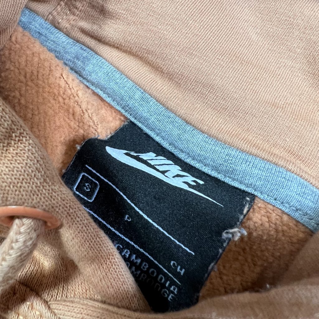 the original nike size small clothing label inside orange hoodie