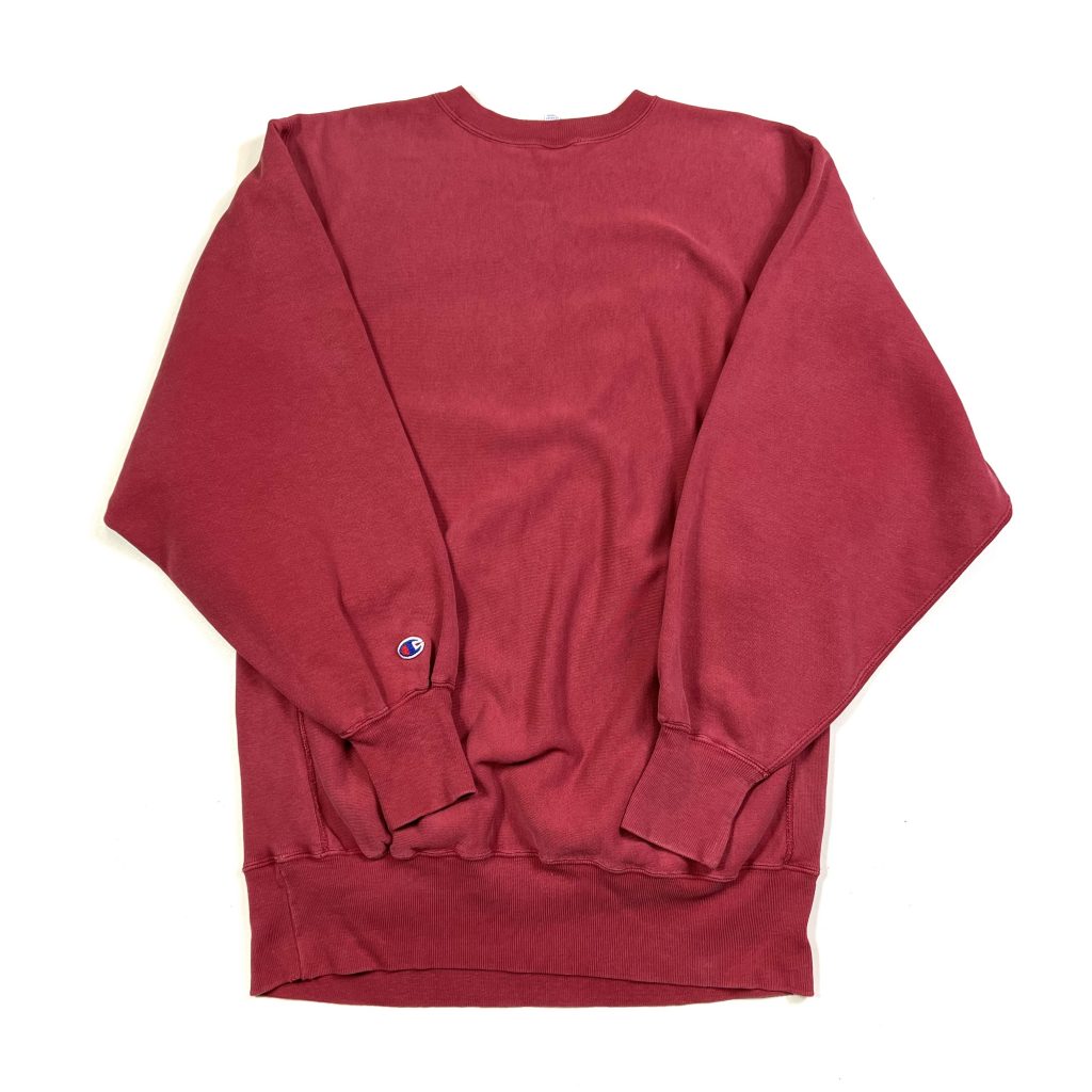 a red champion vintage sweatshirt with embroidered script logo