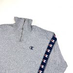 A grey Champion quarter-zip sweatshirt with tape logo sleeves